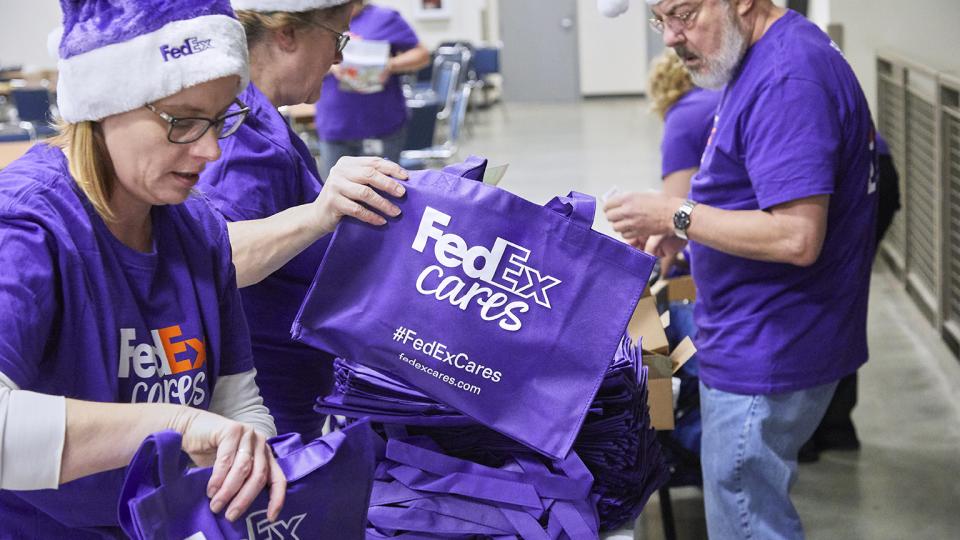 FedEx volunteers packing Purple Totes with donated items