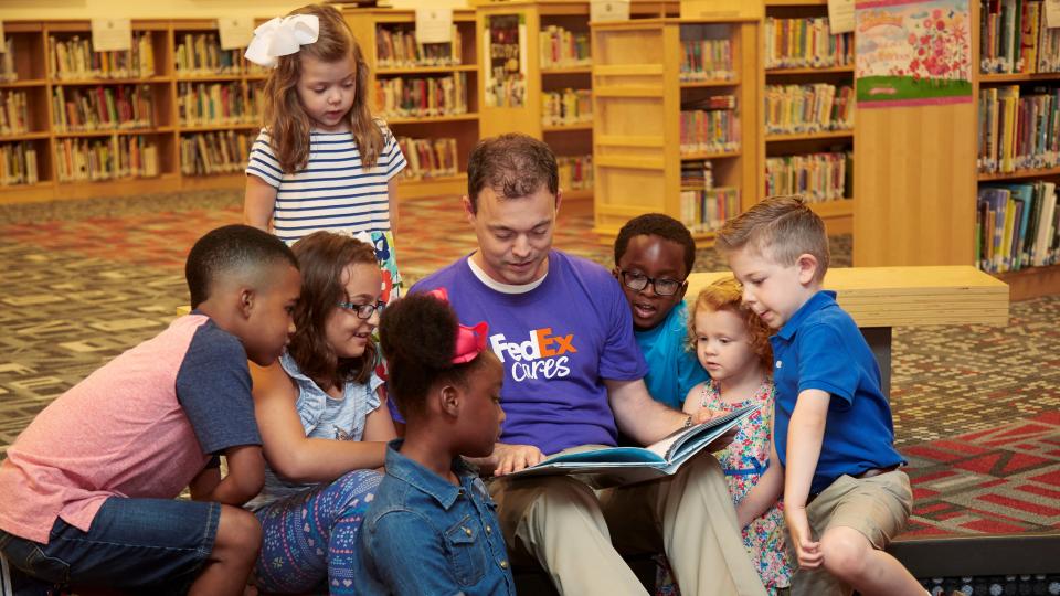 FedEx volunteer reading to children