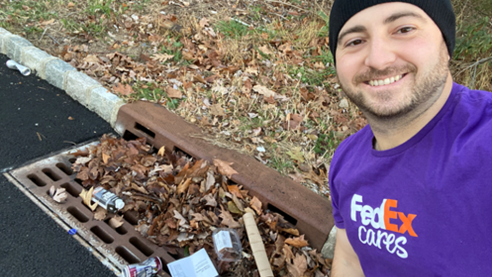 FedEx team member cleaning storm drains