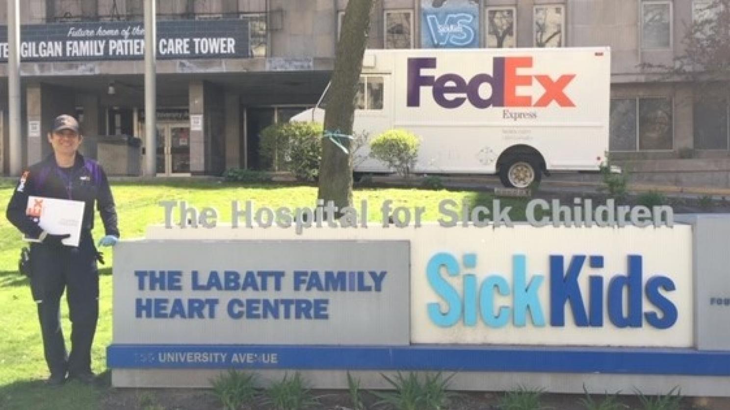 FedEx courier in front of a sign