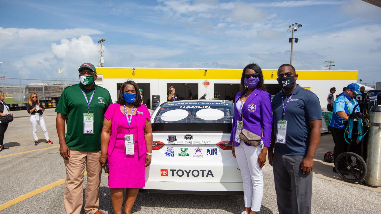 people standing by a race car
