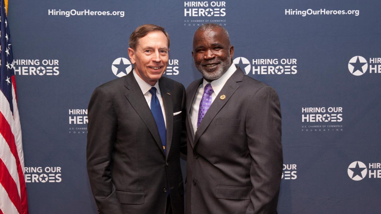 two men in front of the us flag